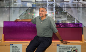 Tayyab Suratwala sitting with two pieces of optical glass