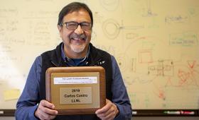 Carlos Castro holds award