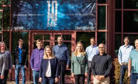 Eleven people stand in front of NIF building