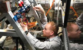 Researcher with hands on complex machinery