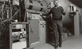 Man stanading next to large scientific equipment