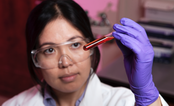 Researcher looking at test tube